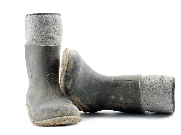 Dirty rubber-soled felt insulated boots shot over white